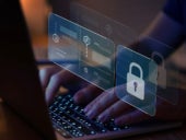 Person using a laptop with cybersecurity tools on virtual screen.