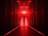 Dark data center corridor with red light on.